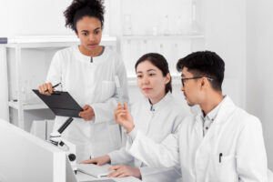 A group of doctors are working together on computers.