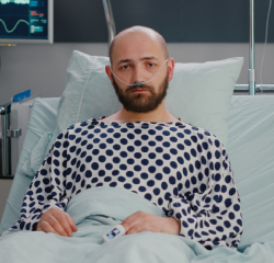 A man in polka dot shirt laying on bed.